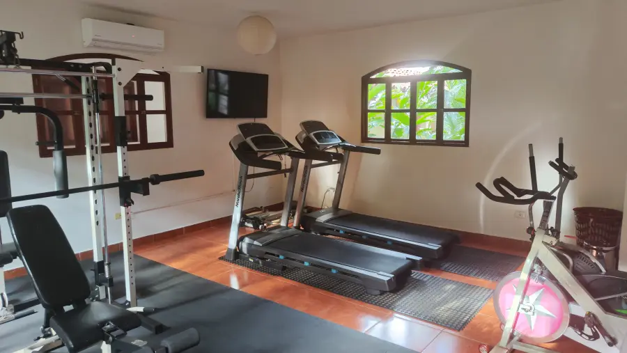 El gimnasio del hotel con caminadoras y equipo de fuerza