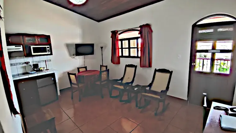Large living room with rocking chairs, dining area, and access to the balcony