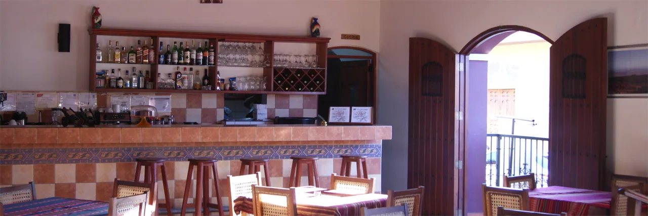La barra de la cafetería con el arco de la entrada al fondo