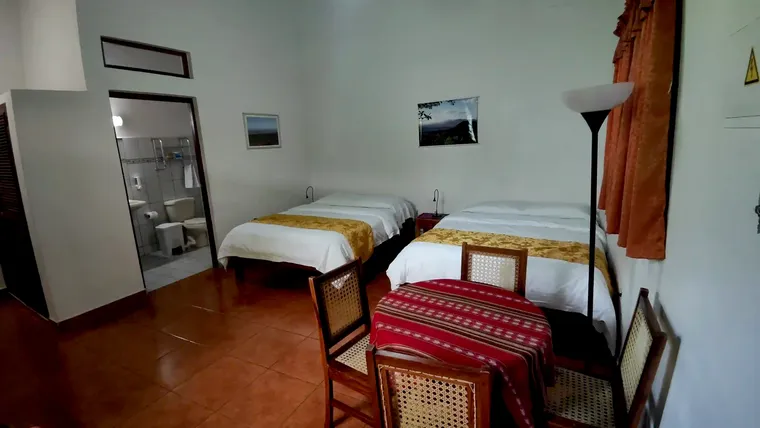 Værelse 4 i haveniveau med to queensize-senge og spiseplads til fire personer