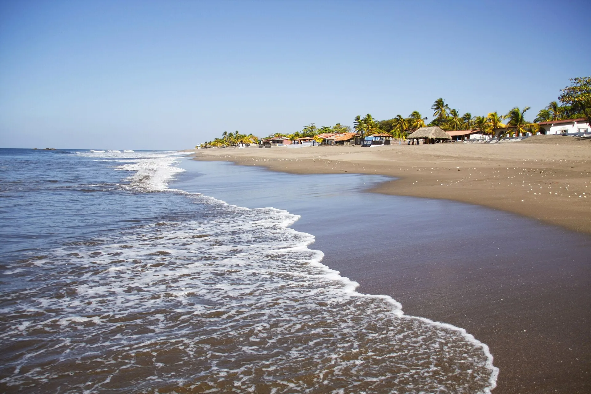 La orilla de Las Peñitas con las olas del Pacífico y las palmeras al fondo