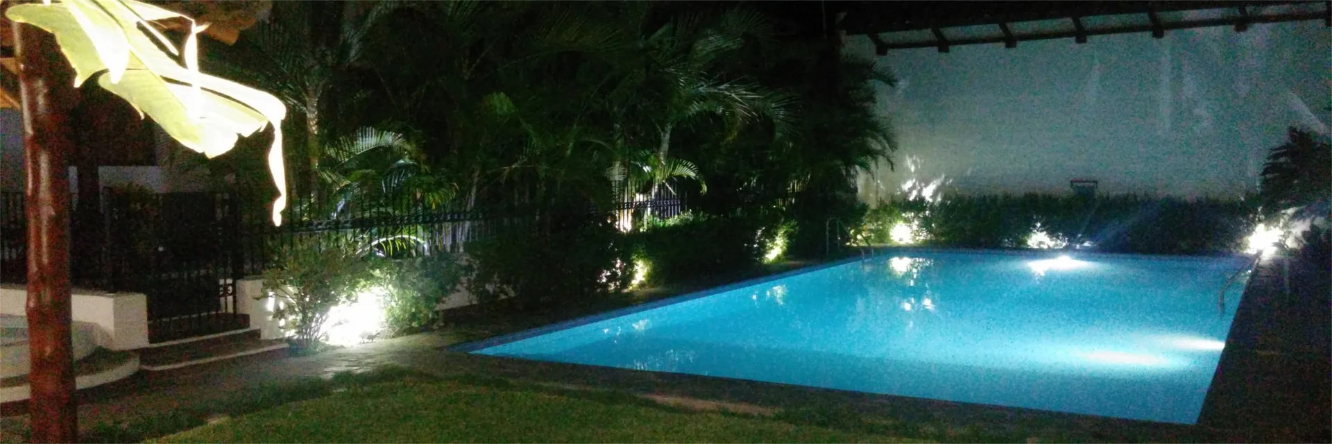 La piscina iluminada al caer la noche